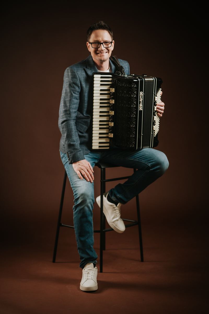 Andrej Švab s harmoniko na barskem stolu